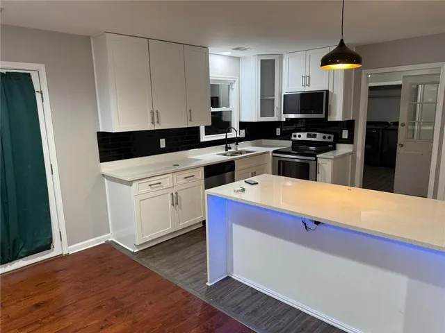 a kitchen with stainless steel appliances a kitchen island wooden cabinets and a counter top space
