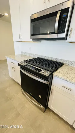 a view of a kitchen with kitchen island stainless steel appliances refrigerator sink and cabinets