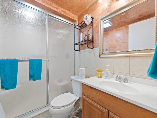 a bathroom with a sink a mirror a toilet and a shower