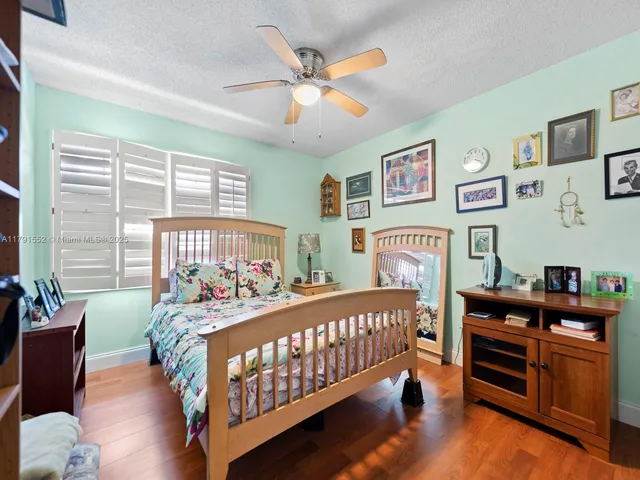 a bedroom with bed baby crib and a window