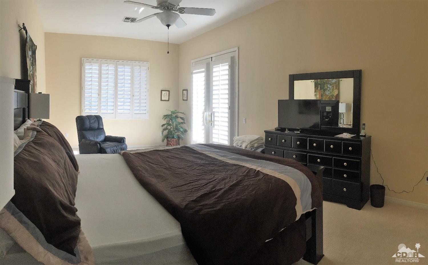 37235 Skycrest Road Palm Desert, CA 92211 - Photo 24 of 34 a bedroom with a bed and a chandelier