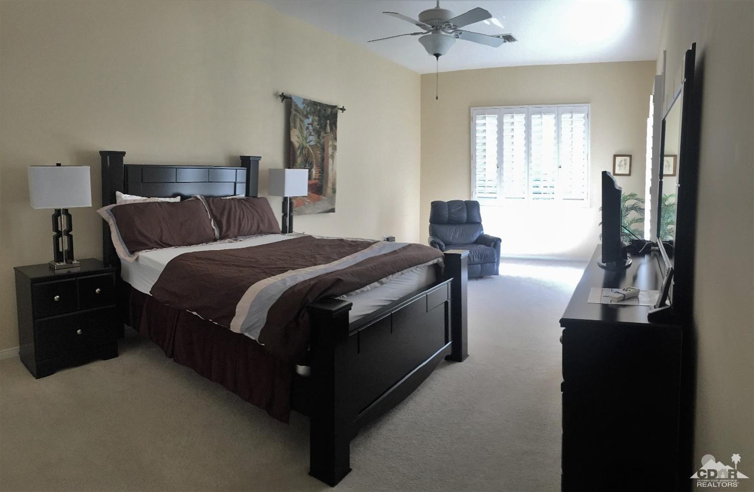 37235 Skycrest Road Palm Desert, CA 92211 - Photo 26 of 34 a bed room with a bed and a chandelier