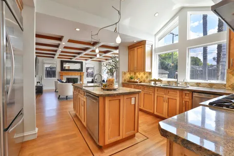 a kitchen with stainless steel appliances kitchen island granite countertop a stove and cabinets