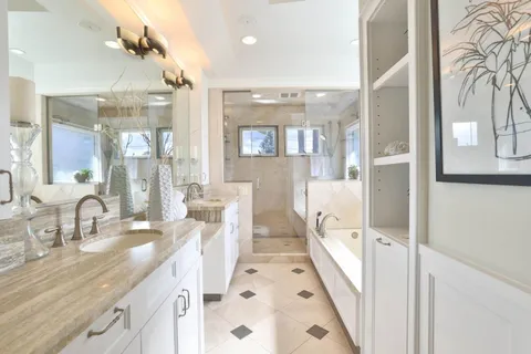 a bathroom with double vanity sinks a mirror and a shower