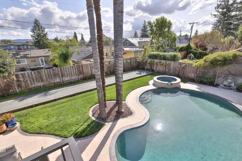 a front view of a house with swimming pool and sitting area