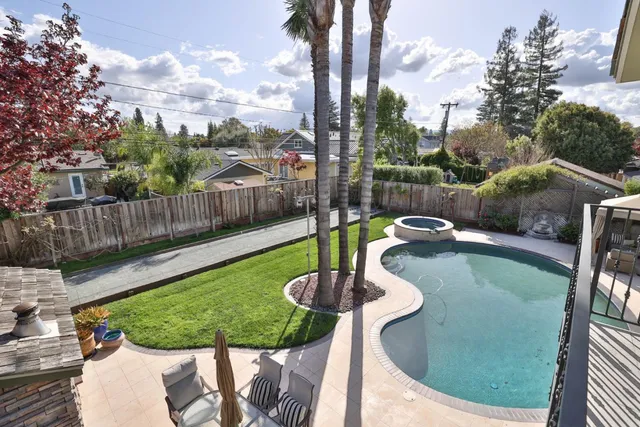 a front view of a house with garden and trees