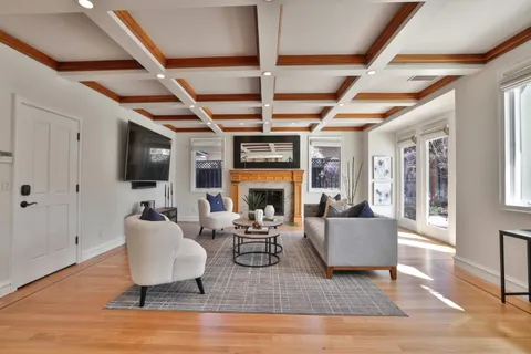 a living room with fireplace furniture flat screen tv and wooden floor
