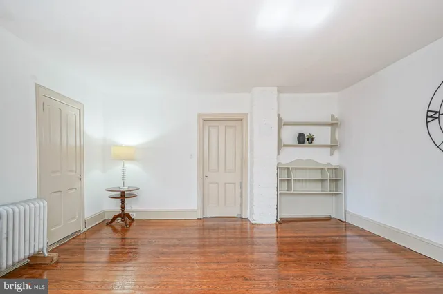 a view of empty room with wooden floor