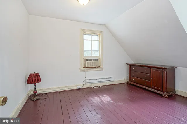 an empty room with a hardwood and a window