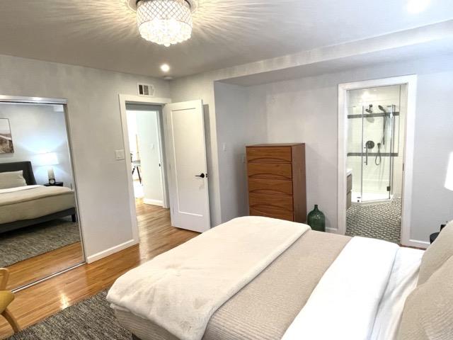 147 Lakeshore Drive San Mateo, CA 94402 - Photo 17 of 36 a bedroom with a bed and a chandelier