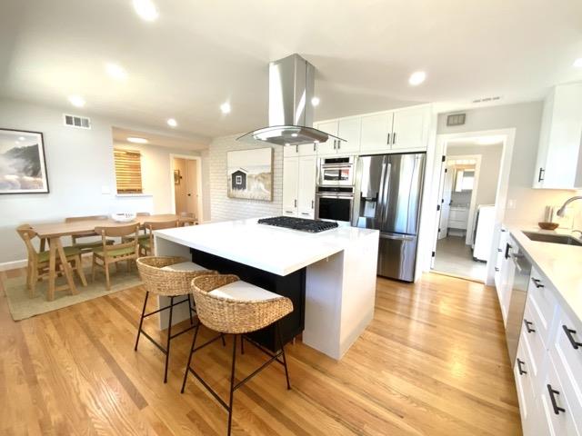 147 Lakeshore Drive San Mateo, CA 94402 - Photo 4 of 36 a kitchen with stainless steel appliances a dining table chairs stove refrigerator and cabinets