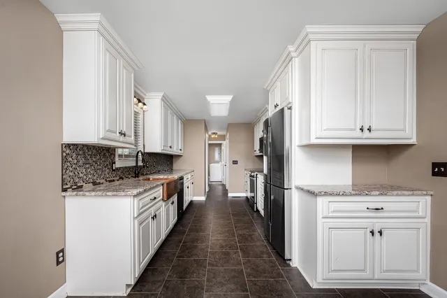 a view of a kitchen with granite countertop a sink and cabinets
