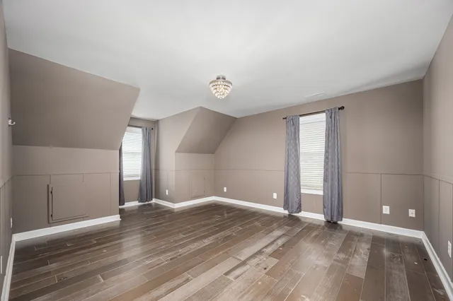 a view of room and bedroom with wooden floor
