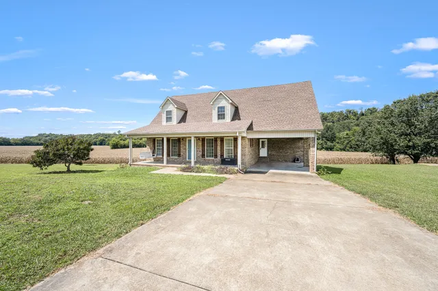 a view of a porch with a table and chairs under an umbrella