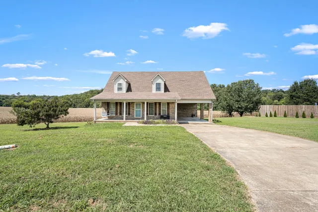 a front view of a house with yard and green space