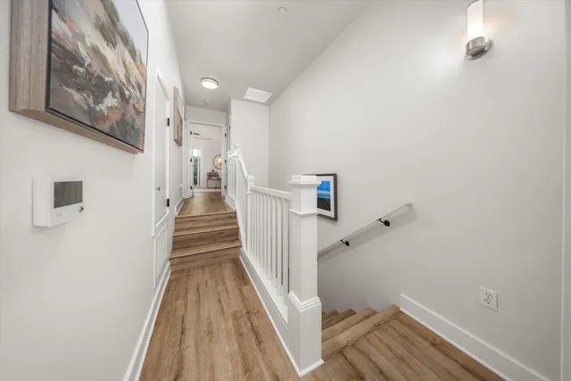 a view of a hallway with wooden floor and staircase
