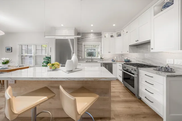 a kitchen with stainless steel appliances kitchen island granite countertop a sink and cabinets