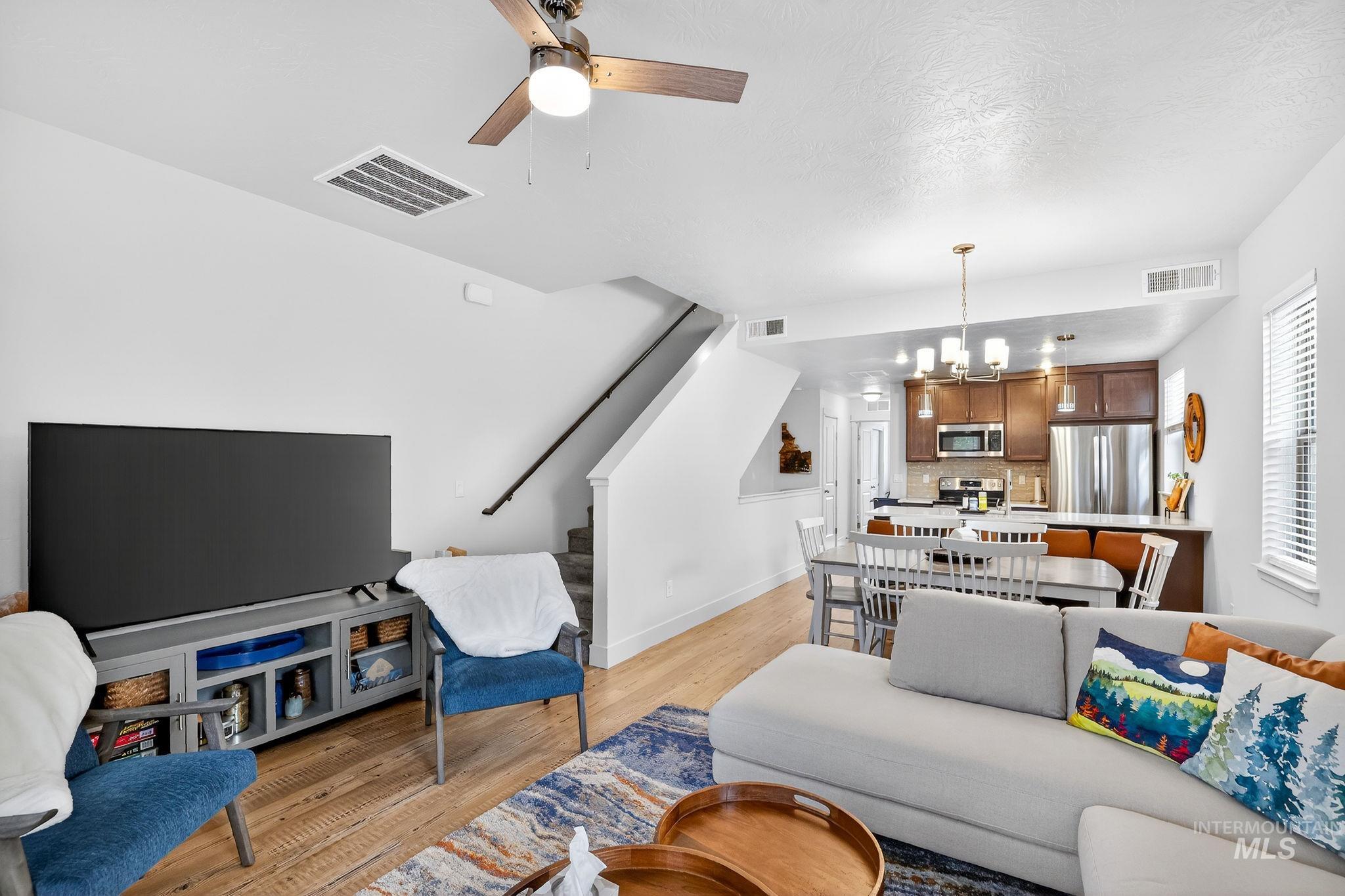 311 Broken Ridge Way McCall, ID 83638 - Photo 6 of 44 Open-concept living space featuring wood-finish flooring, a ceiling fan, and a staircase with a dark handrail