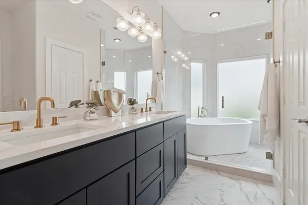 a bathroom with a double vanity sink mirror and bathtub