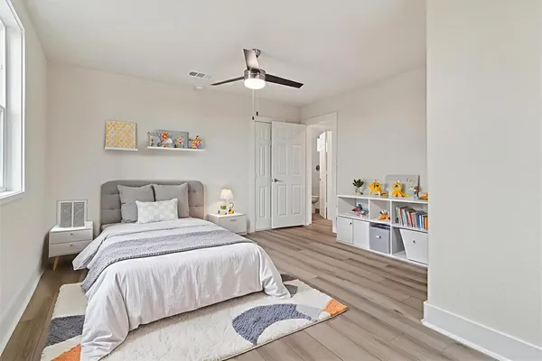 a bedroom with a bed and wooden floor
