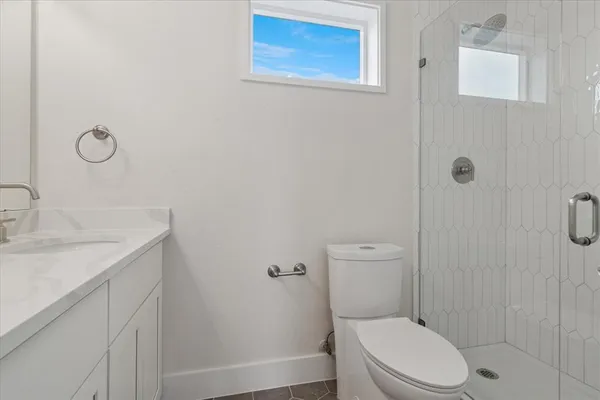 a bathroom with a granite countertop toilet and a sink