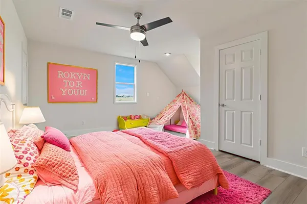a bedroom with a bed ceiling fan and a window