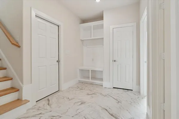 an empty room with a bench and closet