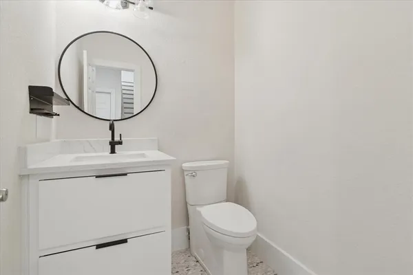 a bathroom with a toilet a sink and a mirror