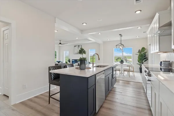 a kitchen with sink stove and wooden floor