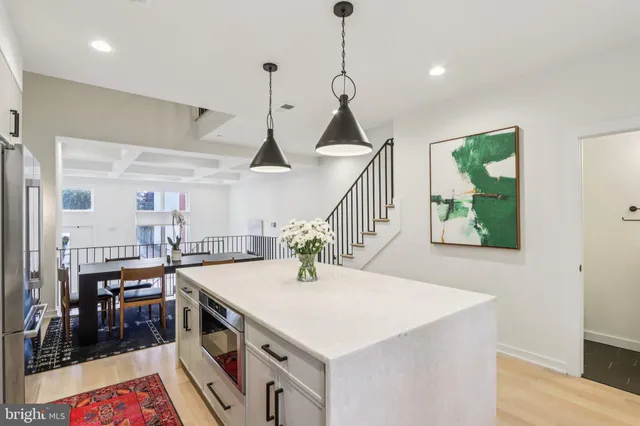a kitchen with a stove a sink and a wooden floor