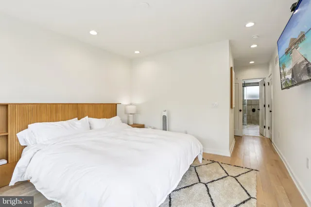 a bedroom with a bed and a painting on the wall