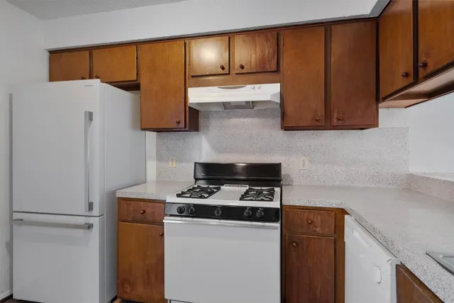 a kitchen with a refrigerator and a stove top oven