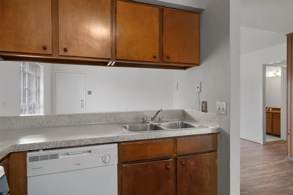 a sink with granite countertop cabinets