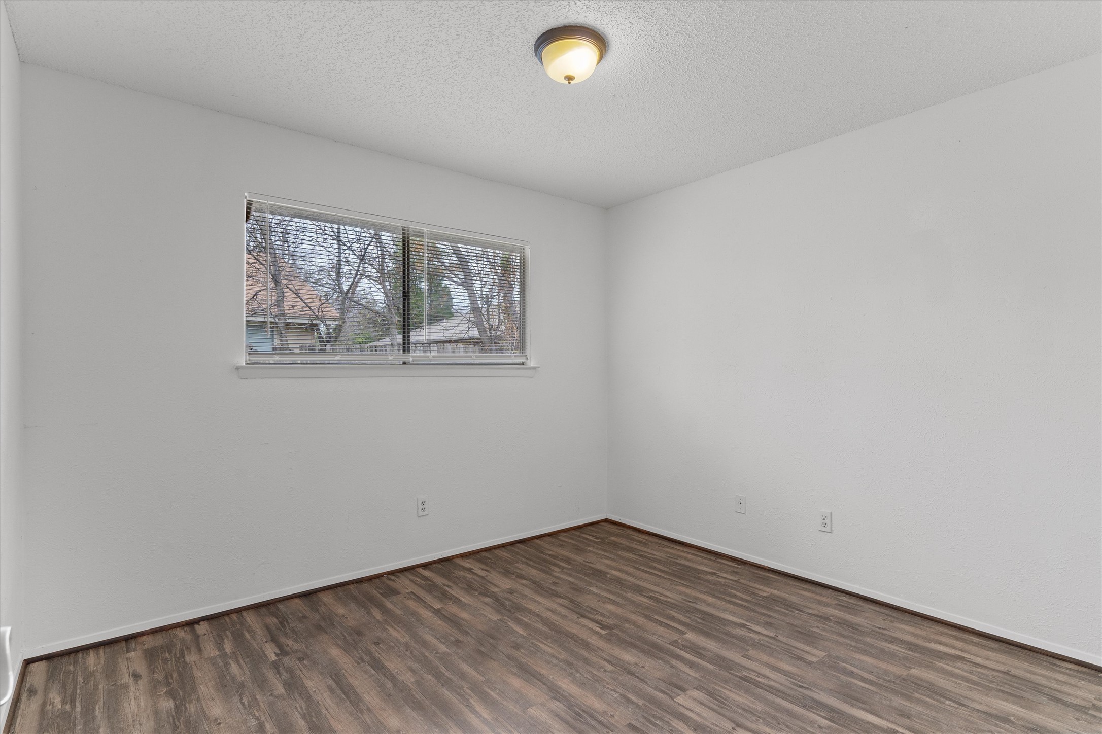 5304 Indio Circle, Unit B Austin, TX 78745 - Photo 19 of 27 an empty room with wooden floor and windows
