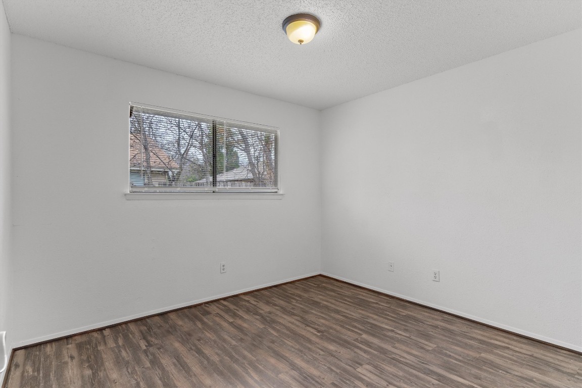 5304 Indio Circle, Unit B Austin, TX 78745 - Photo 19 of 27 an empty room with wooden floor and windows