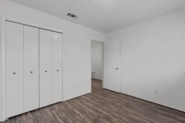 a view of an empty room with wooden floor