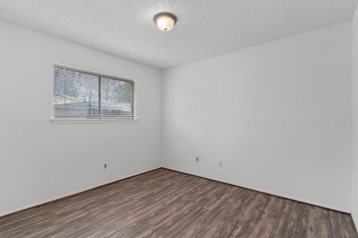 5304 Indio Circle, Unit B Austin, TX 78745 - Photo 21 of 27 an empty room with wooden floor and windows