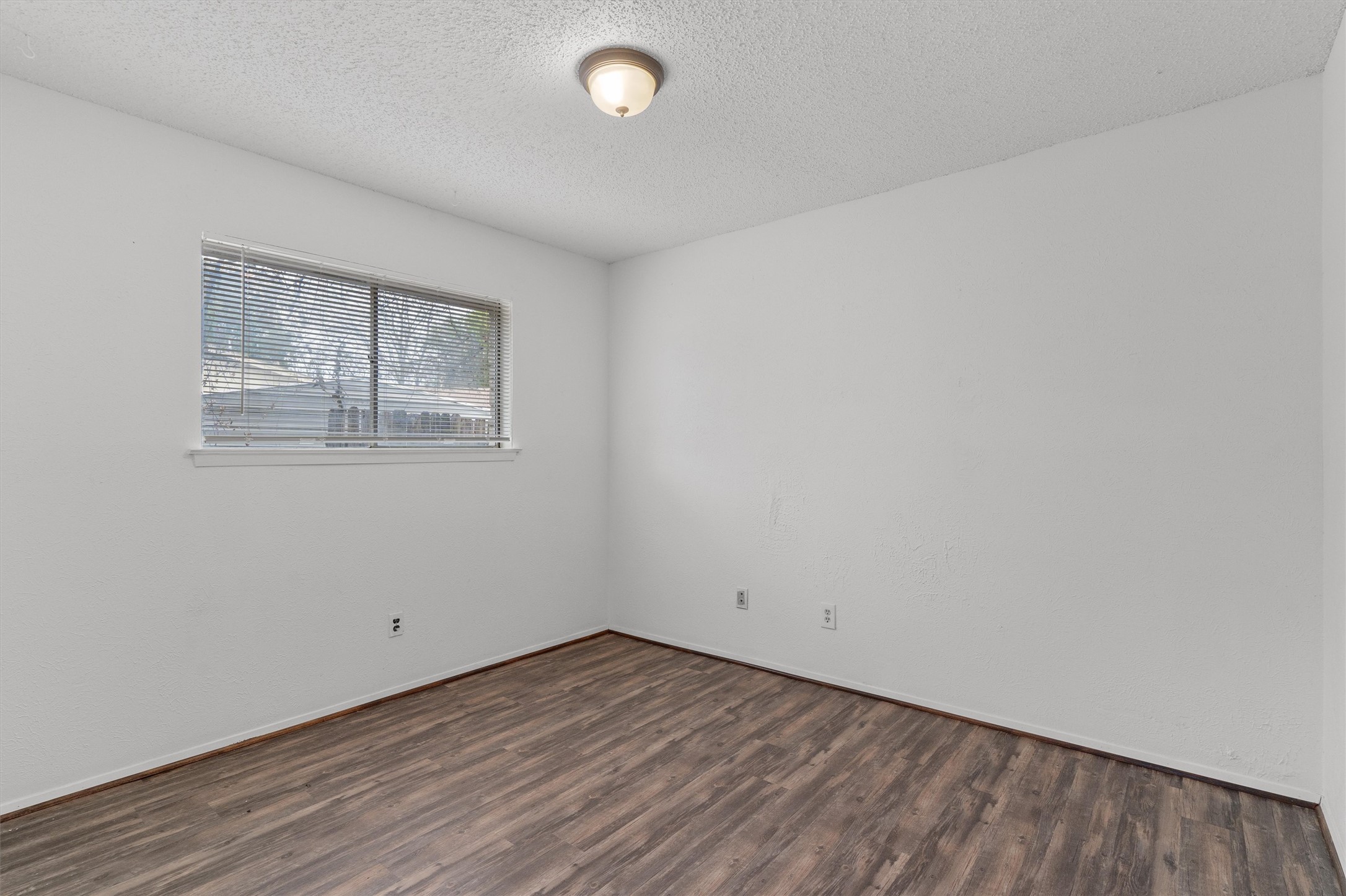 5304 Indio Circle, Unit B Austin, TX 78745 - Photo 21 of 27 an empty room with wooden floor and windows