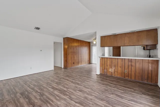 a view of empty room with wooden floor