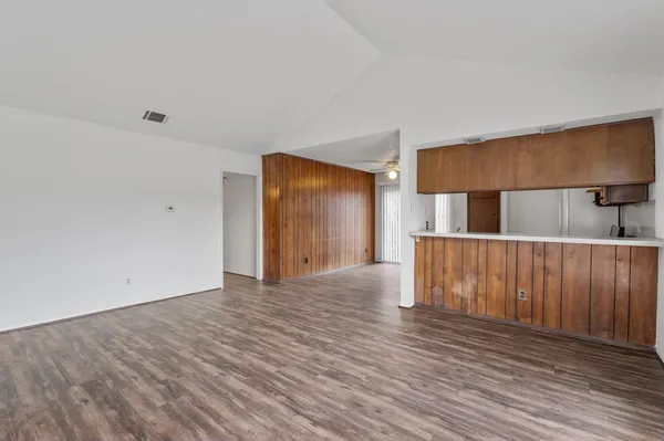 a view of empty room with wooden floor