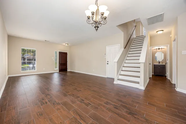 a view of a livingroom with wooden floor and stairs
