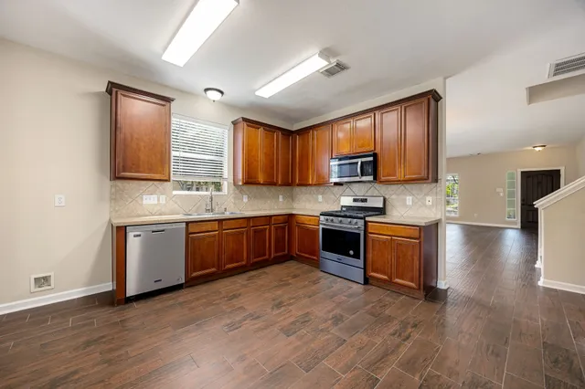 a kitchen with stainless steel appliances granite countertop a stove sink microwave and cabinets