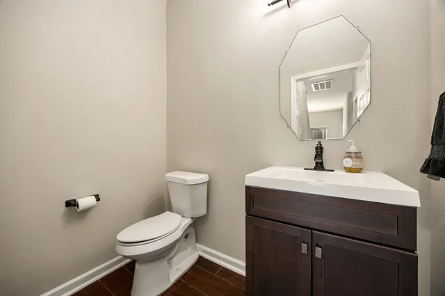 a bathroom with a toilet a sink and mirror