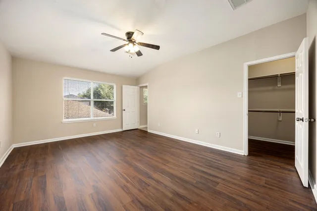 a view of empty room with wooden floor and window