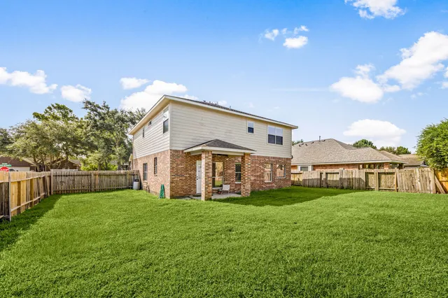 a view of a house with a big yard and large trees