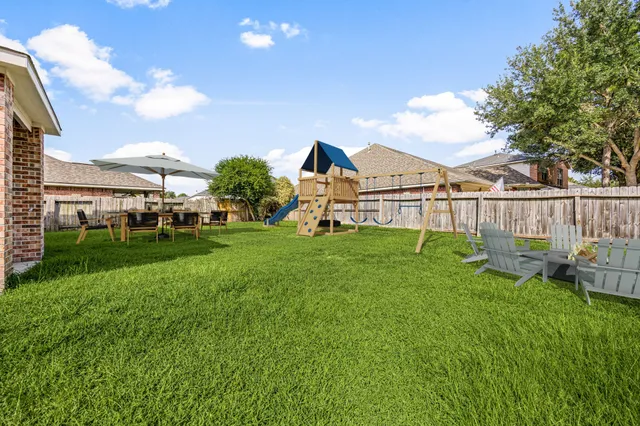 a view of a house with backyard and sitting area