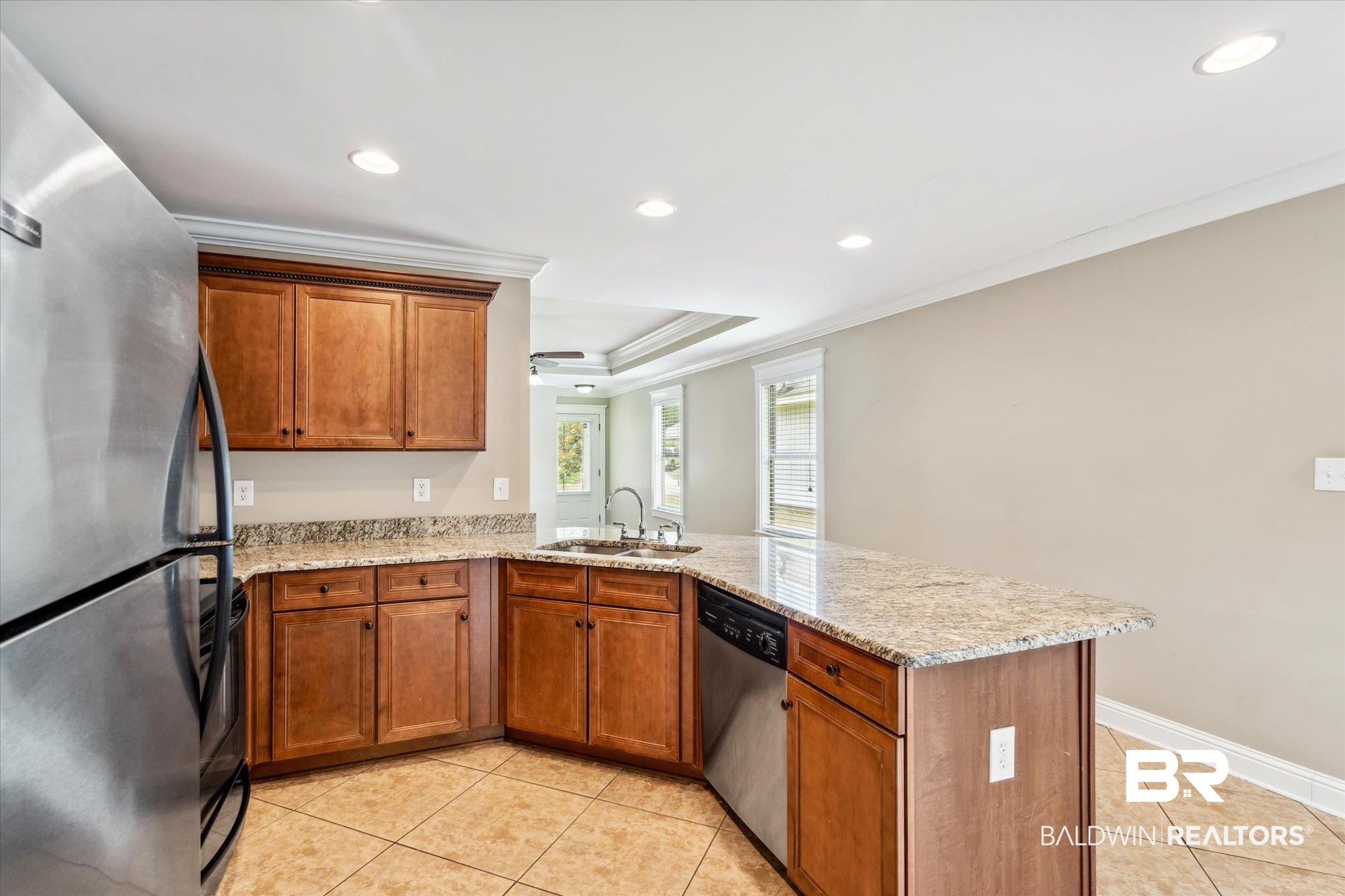 9 Breydon Court Mobile, AL 36608 - Photo 7 of 20 Kitchen featuring stainless steel appliances, crown molding, sink, a raised ceiling, and light tile patterned floors