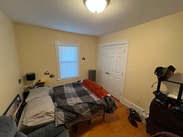 a bedroom with a bed and wooden floor