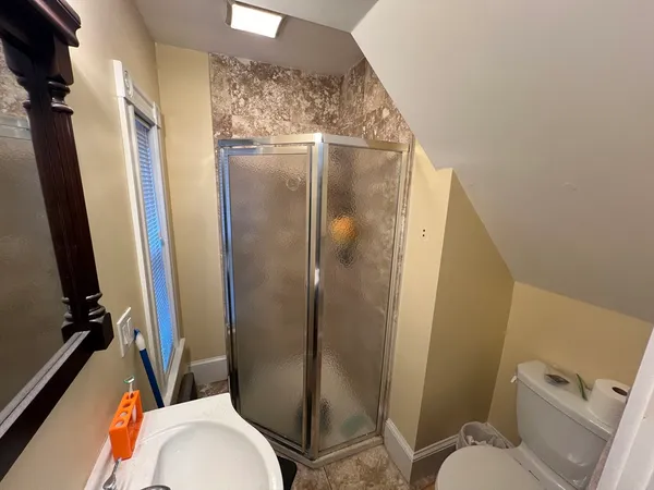 a bathroom with a granite countertop toilet sink and shower
