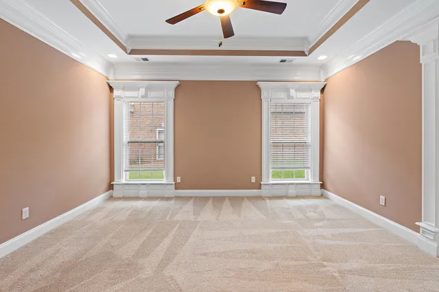 a view of an empty room with window chandelier fan